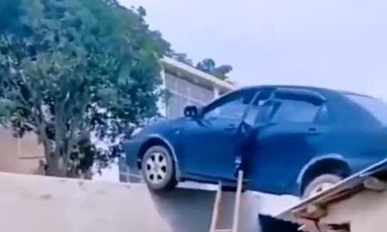 Nữ tài xế lùi ôtô lên mái nhà